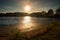 Sunset above empty lake, reeds and reflections on the shore. Beautiful summer landscape.