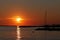 Sunset above rocky molo and anchored yacht silhouette in Croatia