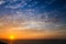 Sunset above the sea landscape panorama with full yellow sun reflections over the Atlantic Ocean and beautiful blue sky with white