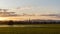 Sunset across a flooded meadow, on a October evening. With a church spire silhouetted against the sky. With the Malvern Hills in