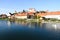 At sunset, the ancient buildings and reflections along the river in Ptuj with blue sky