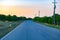 at sunset an asphalt road goes towards the mountains