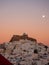 sunset in Astypalaia with the full moon rising and a red windmill in the foreground