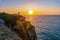 Sunset at Atlantic rocky coast, Portugal. Photographer taking shot of andscape