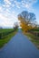 Sunset autumn landscape at countryside. Road along horse farms