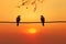 Sunset backdrop frames bird couples silhouette on wire symbolizing affection