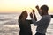 Sunset, beach and couple with sparklers for celebration, party and quality time on romantic date. Nature, love and happy
