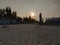 Sunset on the beach. Deserted beach. Rusty fences. The sun behind the clouds falls over the horizon. Sand. The Trees. Coast.