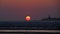 Sunset on the beach of Essaouira, Morocco, Africa over the rough Atlantic sea with yellow and orange discolored sun on horizon.