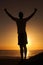 Sunset, beach and silhouette of fitness man with arms up celebration in nature, excited or victory. Energy, shadow and