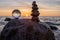 Sunset on the beach with a stack of stones in the foreground -Stone pyramids and glass sphere on the dreamy Baltic Sea