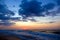 Sunset on beach. Stormy sea, cloudy sky.