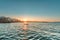 Sunset on the beach with sun rays reflected in the water