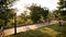 Sunset in a Beautiful Park. People are resting among the green trees