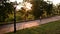 Sunset in a Beautiful Park. People are resting among the green trees