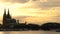 Sunset behind Cologne Cathedral with boats sailing on the River Rhine, Germany