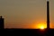 Sunset behind a factory chimney