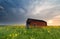 Sunset behind farmhouse on rapeseed field