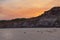 Sunset behind rocks on the beach with Seagull on the sand