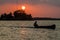 Sunset behind Santa Barbara islet with a boat crossing Peten Itza lake near Flores city, Guatema