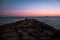 sunset with blue, purple and orange colors from a stone breakwater in southern Spain