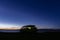 Sunset blue sky and camper van silhouette on the beach near the sea. Free parking and traveling through beautiful landscape -