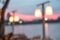 Sunset blur sky pink twilight background on peaceful river bank view with blurry illuminated lamp on pier from restaurant dining