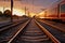 Sunset casts a warm glow on the train platform beside the railroad