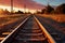 Sunset casts a warm glow on the train platform beside the railroad