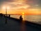 Sunset  city on pier promenade people  walk relaxing street lamp light reflection on blue sky and sea water  tree branch and