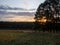 sunset on a clear day over a wooded ravine