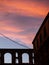 Sunset clouds in the old part of town - abandoned building and ancient Roman aqueduct in the background