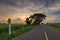 Sunset in clouds with sunrays over road