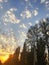 Sunset cloudy sky with picturesque clouds lit by warm sunset sunlight. Country road at sunset