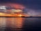 Sunset cloudy starry night dark dramatic blue lilac gold orange sunset at sea water reflection boat on horizon in harbor nature la