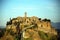 Sunset colors of the village of Civita di Bagnoregio on the eroded tuff cliff, in the Calanchi valley, Civita di Bagnoregio, Tusci