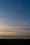 Sunset in the countryside with wind turbines and a plane with contrails in the sky