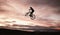 Sunset, dirt bike and jump with action in outdoor with sport in nature for adventure or risk. Motorcycle, silhouette and