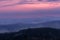 Sunset with distant hill and fog from Tristolicnik. Blue hour. Sumava National Park and Bavarian Forest, Czech republic and