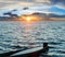 Sunset and drowned boat on summer lake bank