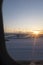 Sunset dusk shining on a snowy landing airport track seen from an airplane window