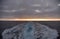 Sunset at the end of water mark left after sailing cargo ship.