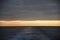 Sunset at the end of water mark left after sailing cargo ship.