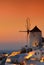 Sunset at famous windmills at beautiful Oia village , Santorini