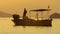 At sunset, the fisherman pulls the chain of his boat out of the sea. silhouette image.