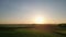 Sunset flyover: aerial journey over a tranquil farm field