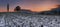 Sunset on frozen field with a chapel.