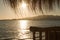 Sunset glittering water silhouettes through beach straw parasols