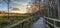 Sunset golden sky over the bare trees and boardwalk