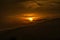 Sunset of the golden solar disk in the sky, late autumn evening over the mountainous terrain of Armenia